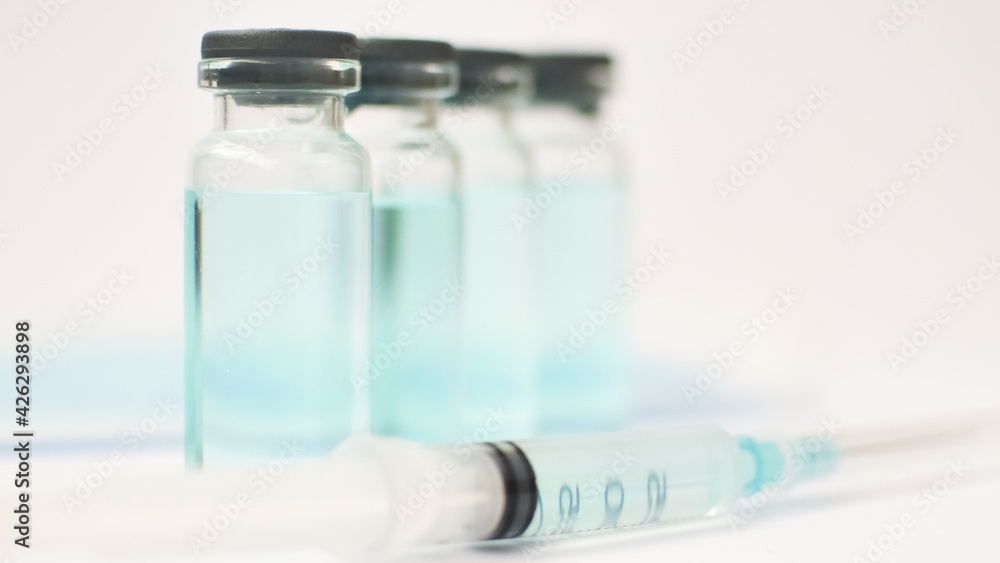 Medical ampoules and insulin syringe isolated on white background, vaccination concept Medical ampoules and insulin syringe isolated on white background, vaccination concept