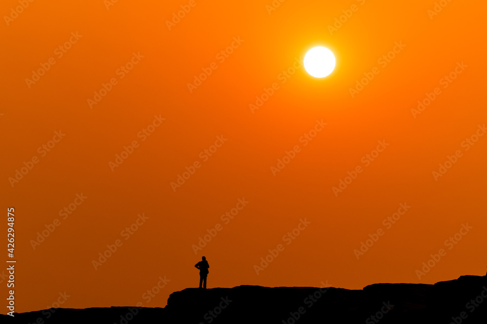 the sunset and orange gold scene small people on mountain foreground