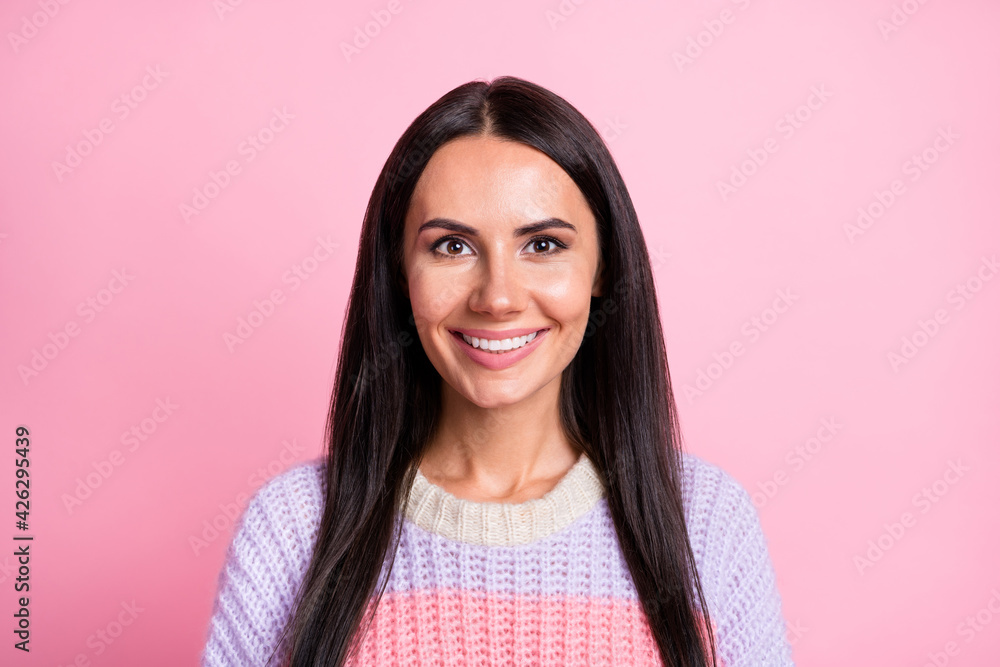 Portrait of pretty cheerful long-haired girl wearing warm sweater isolated over pink pastel color background Portrait of pretty cheerful long-haired girl wearing warm sweater isolated over pink pastel color background