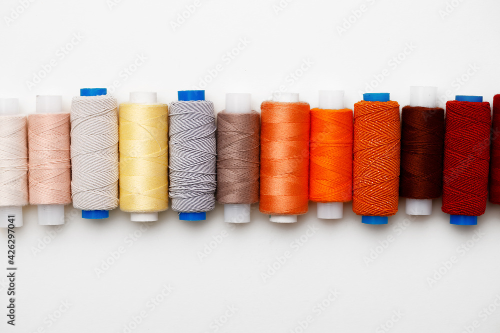 Colored spools of threads on white background Colored spools of threads on white background