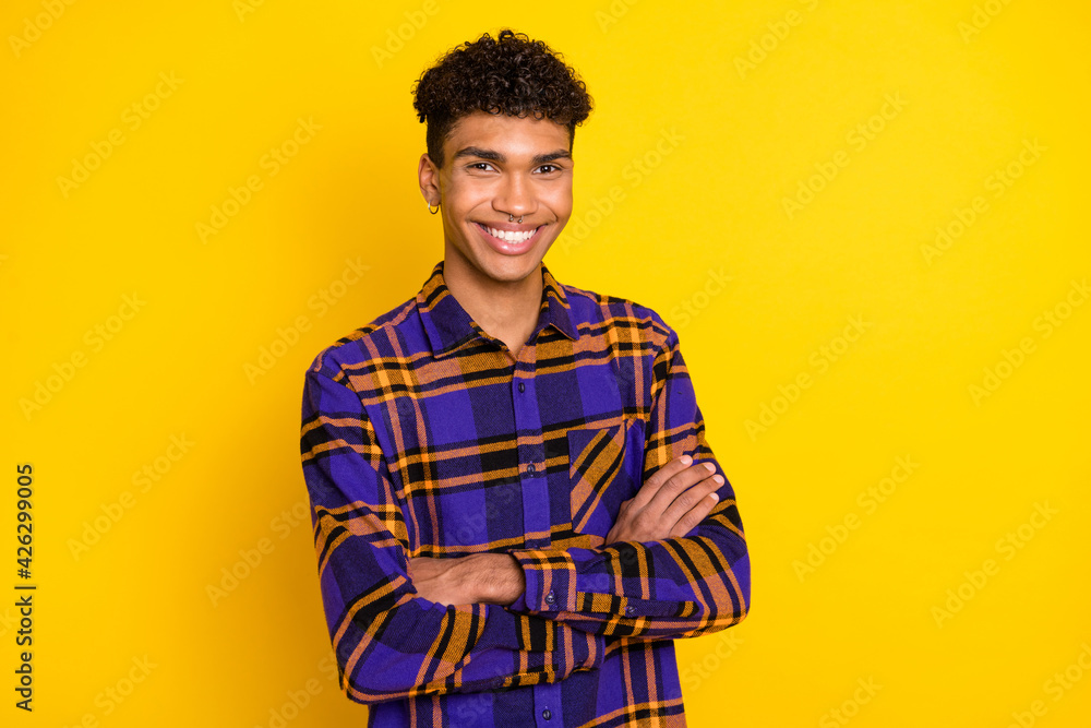 Photo portrait of young man smiling confident folded hands plaid shirt isolated bright yellow color background Photo portrait of young man smiling confident folded hands plaid shirt isolated bright yellow color background