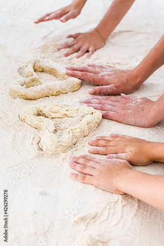 family, a young mother with her daughter and son made a heart out of dough in the kitchen