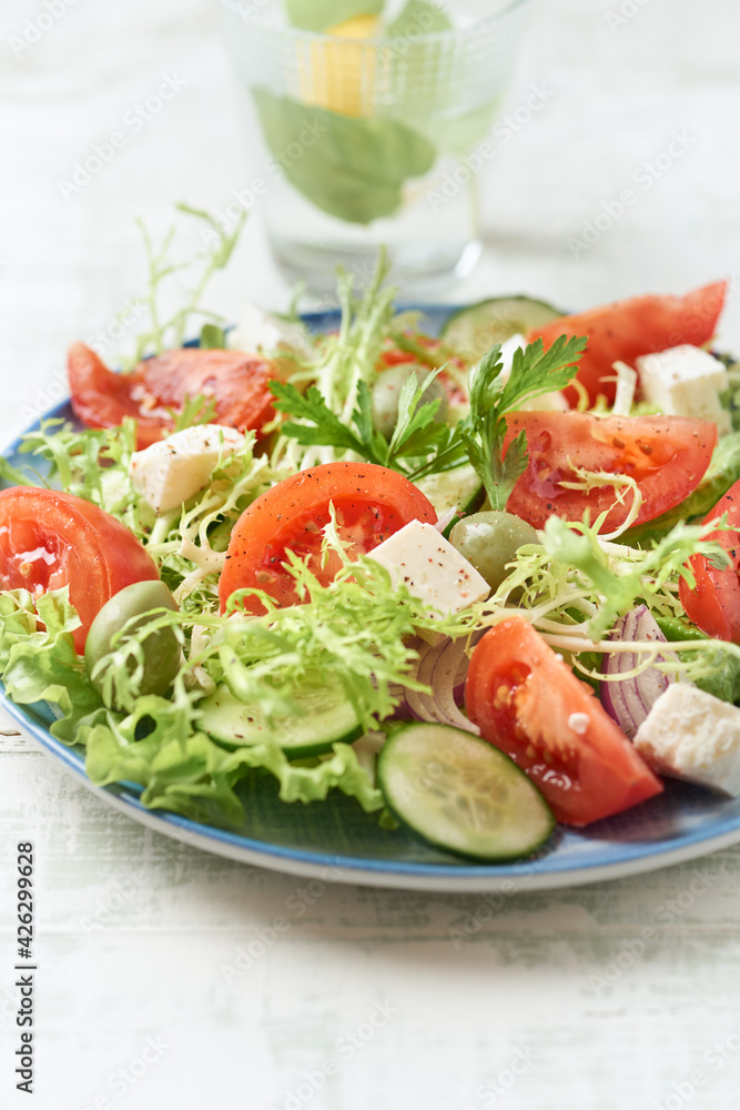 Salad with Green Olives, Tomatoes and Feta Cheese. Bright wooden background. Close up. Salad with Green Olives, Tomatoes and Feta Cheese. Bright wooden background. Close up.