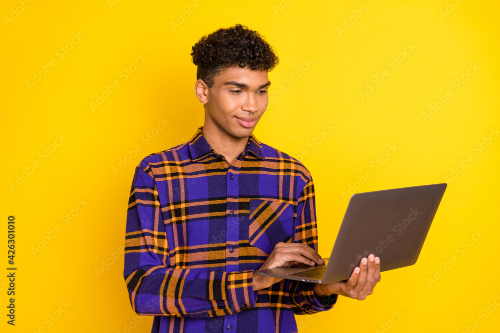 Photo of young afro man look browse laptop chat type email programmer isolated over yellow color background Photo of young afro man look browse laptop chat type email programmer isolated over yellow color background