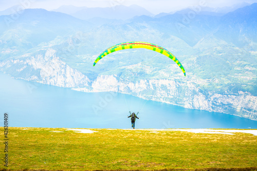 Gleitschirmfliegen am Gardasee mit Bergpanorama im Hintergrund See Paragleiter Italien Sport Berg / Paragliding at Garda lake in Italy Mountains Alps Paragliter 