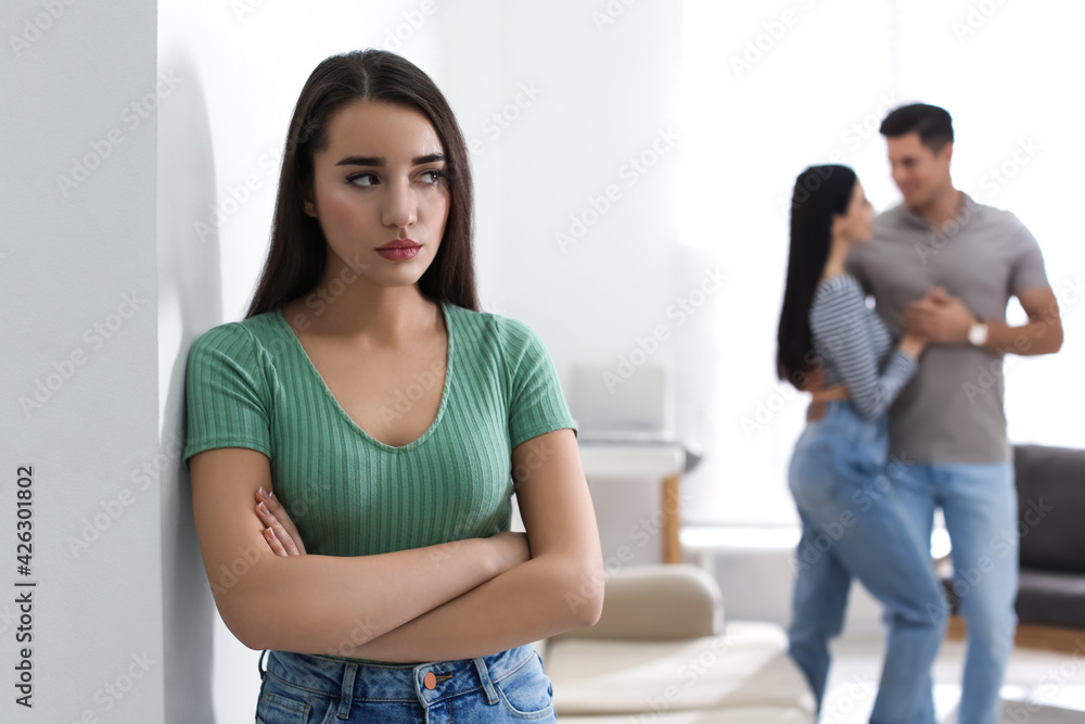 Unhappy woman feeling jealous while couple spending time together at home Unhappy woman feeling jealous while couple spending time together at home