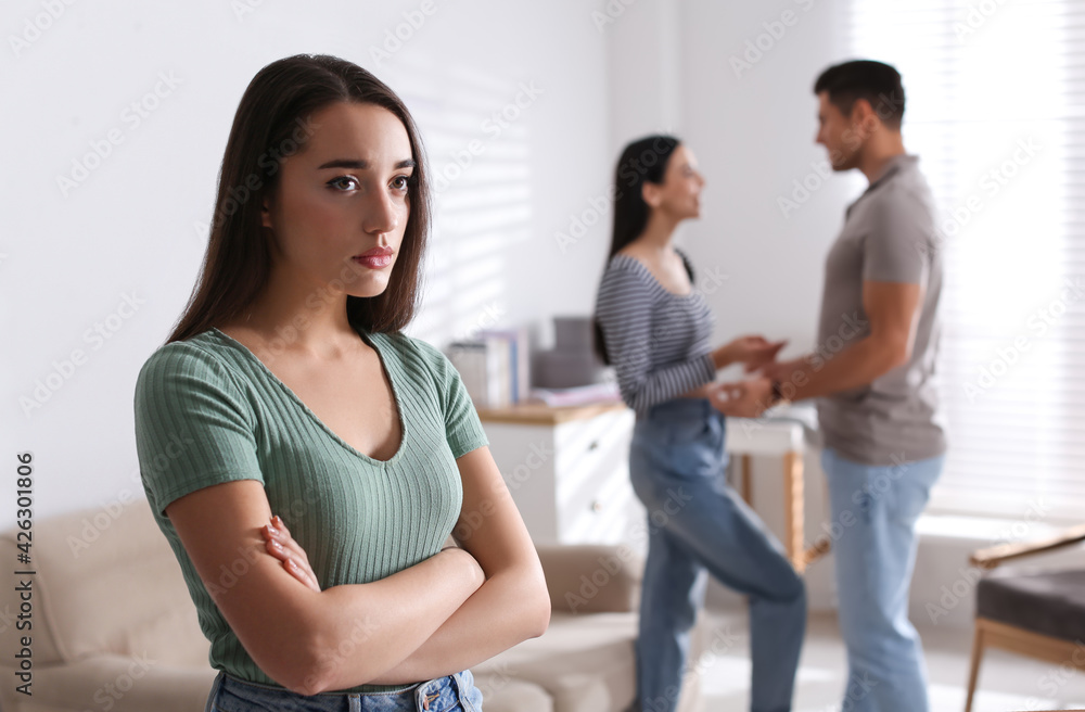 Unhappy woman feeling jealous while couple spending time together at home Unhappy woman feeling jealous while couple spending time together at home