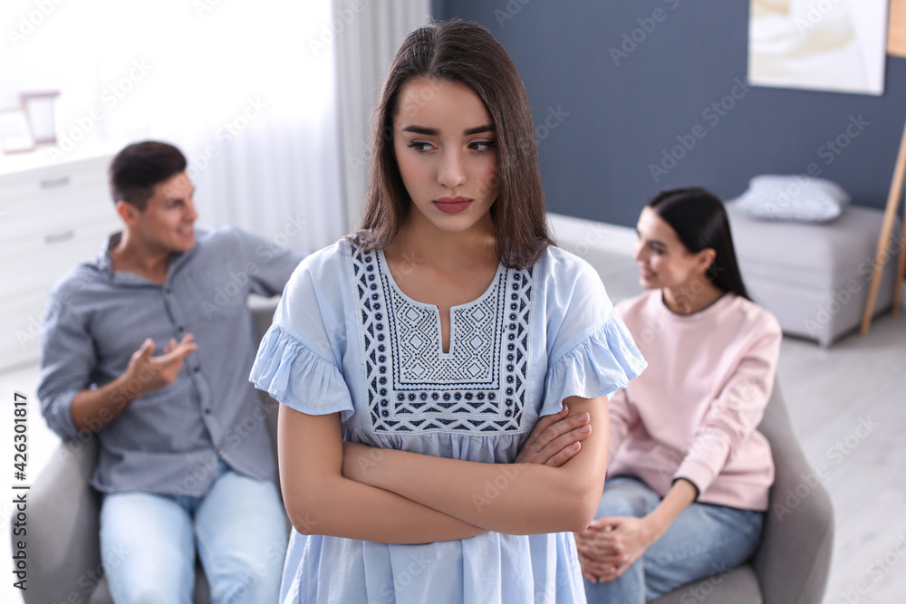 Unhappy woman feeling jealous while couple spending time together at home Unhappy woman feeling jealous while couple spending time together at home
