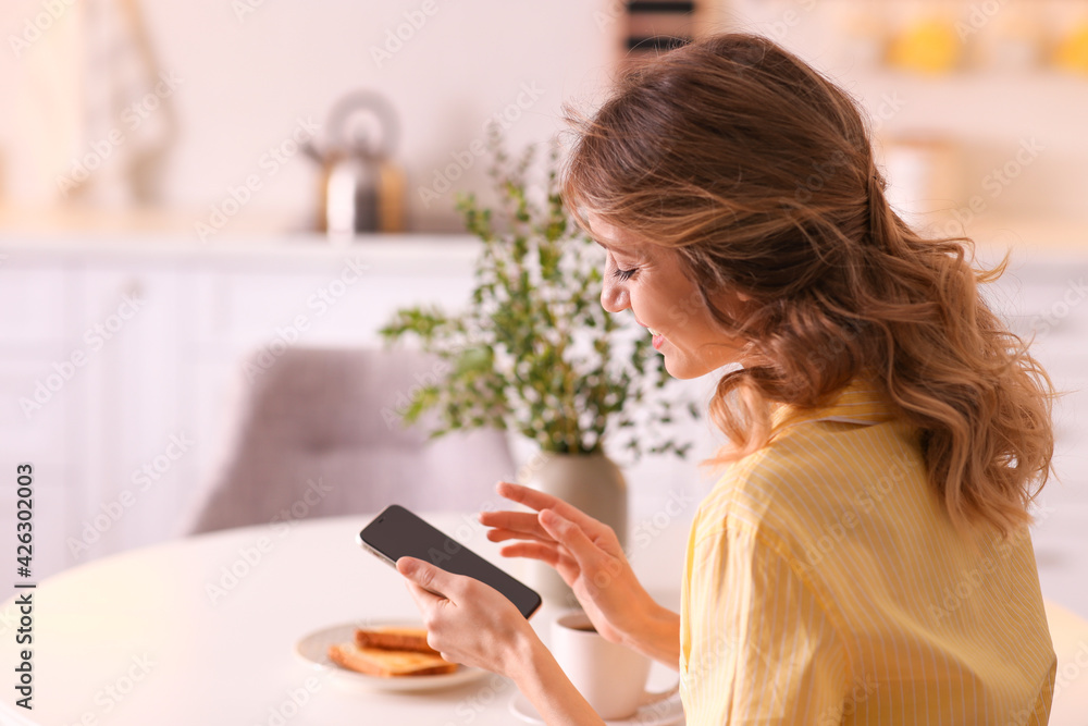 Beautiful young woman with smartphone relaxing at home. Weekend morning Beautiful young woman with smartphone relaxing at home. Weekend morning