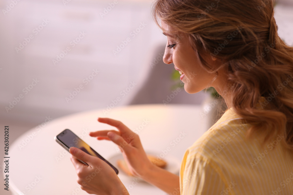 Beautiful young woman with smartphone relaxing at home. Weekend morning Beautiful young woman with smartphone relaxing at home. Weekend morning