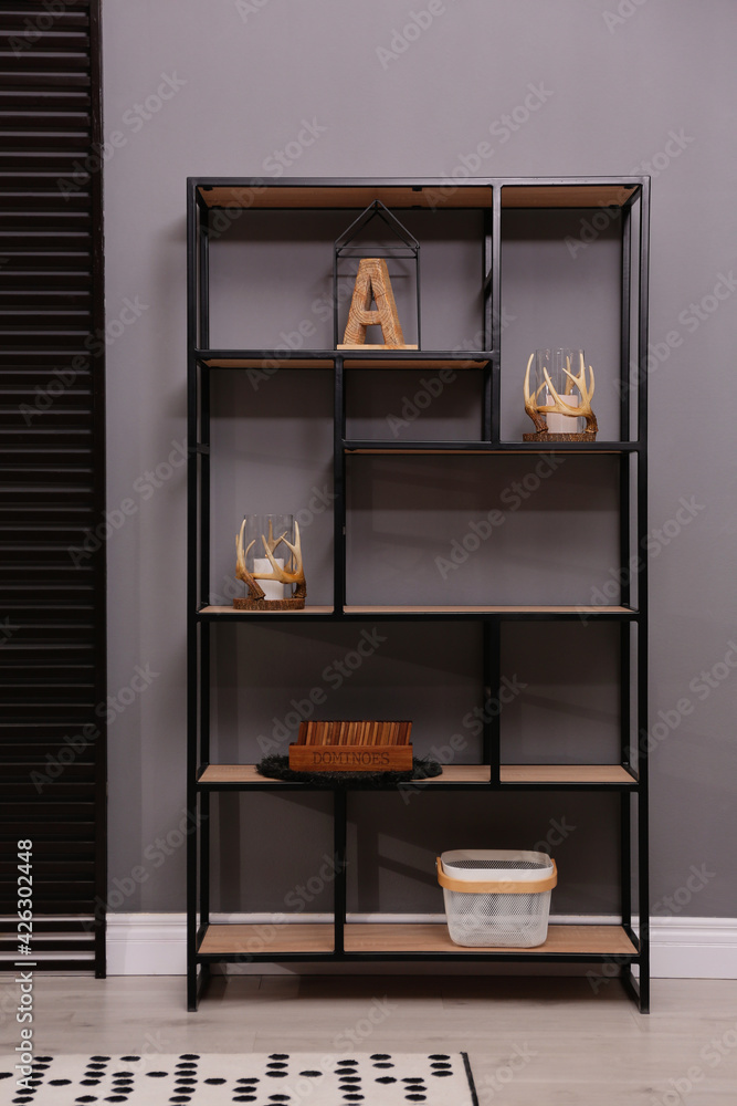 Stylish shelving unit with decor near grey wall indoors. Interior design Stylish shelving unit with decor near grey wall indoors. Interior design