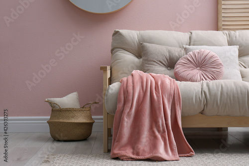 Modern living room interior with comfortable sofa and pink blanket