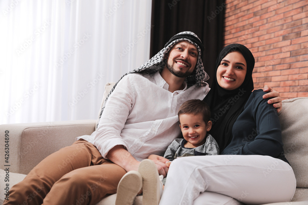 Happy Muslim family spending time together on sofa at home Happy Muslim family spending time together on sofa at home