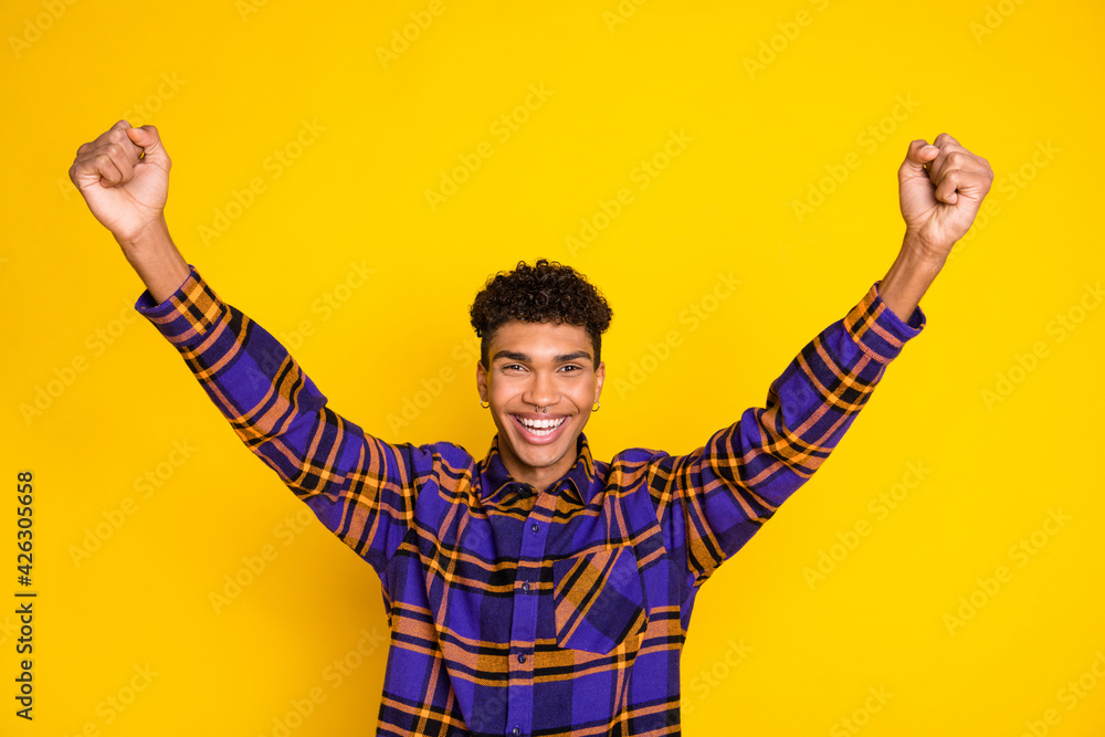 Fototapeta premium Photo of young excited black guy happy positive smile rejoice victory fists hands isolated over yellow color background