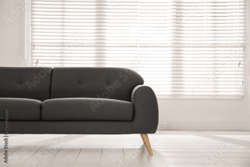 Comfortable grey sofa near window indoors. Interior design