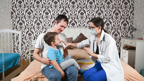 The doctor treats a child's runny nose