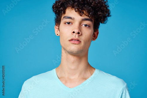 guy in blue t-shirt curly hair cropped view isolated background