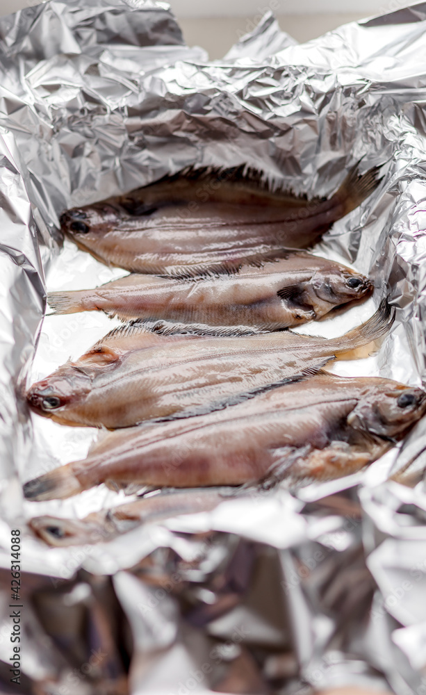 Raw flounder fish, seafood on baking foil. Healthy eating concept.
