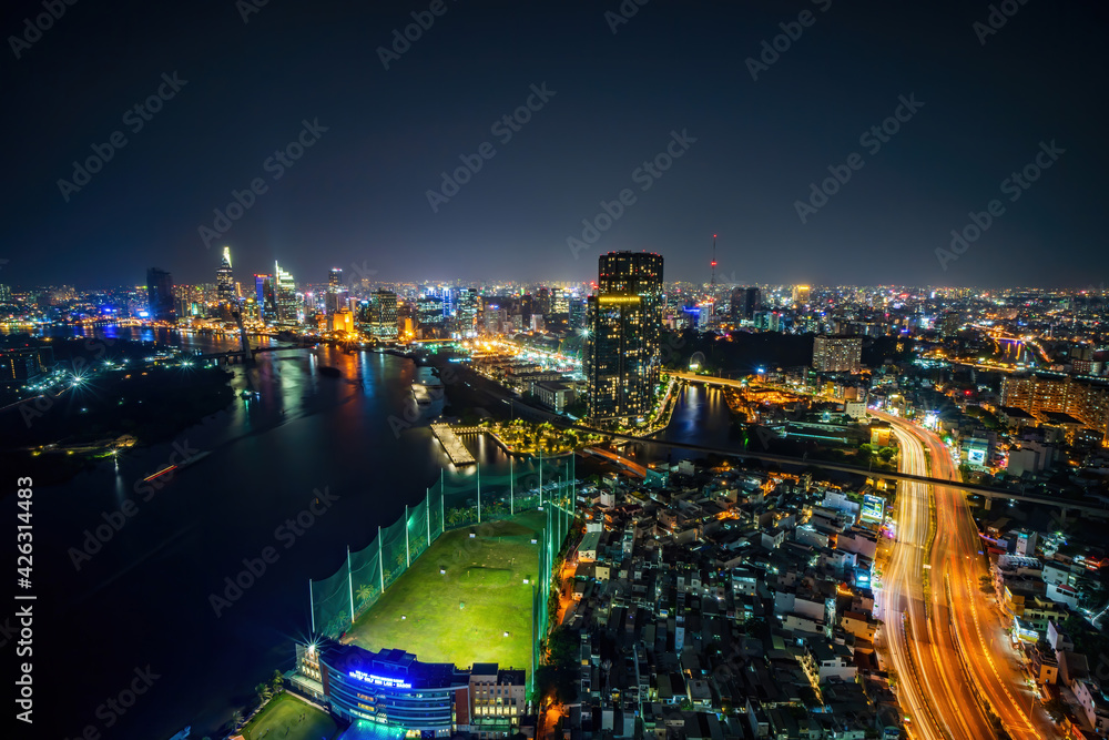 Fototapeta premium Aerial view of Ho Chi Minh city, Vietnam. Beauty skyscrapers along river light smooth down urban development. Dramatic lighting spectacular night.