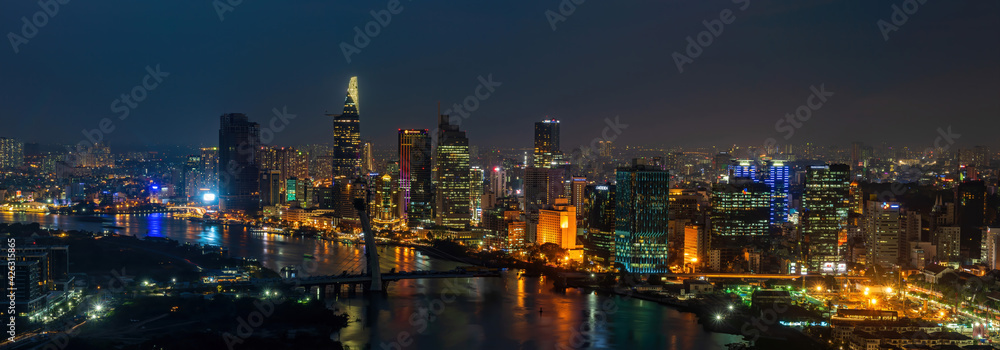 Aerial view of Ho Chi Minh city, Vietnam. Beauty skyscrapers along river light smooth down urban development. Dramatic lighting spectacular night.