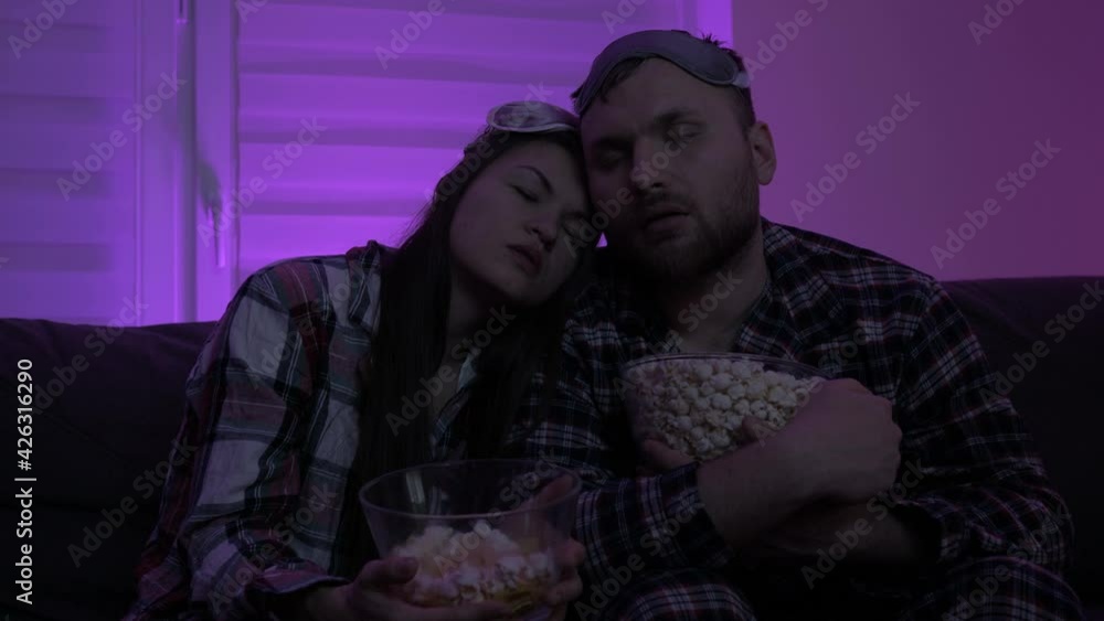 Young married couple fell asleep while sitting on the couch while watching TV. Young married couple fell asleep while sitting on the couch while watching TV.