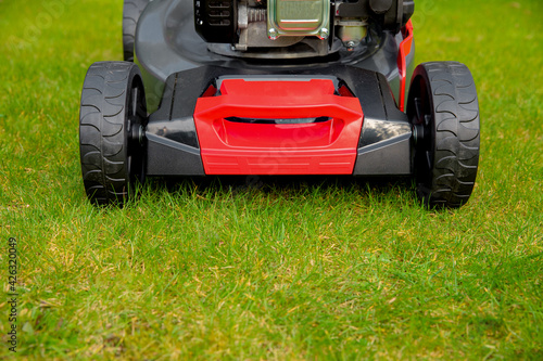 Lawn mower on green grass. mowing machine on a green surface. Lawn care in spring and summer. 