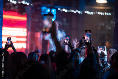 Person close up of recording video with smartphone during a concert. © teksomolika