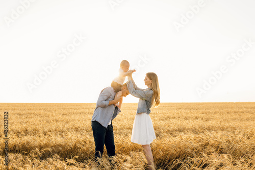 Happy family, Mother, father and son walk in the wheat field and enjoy