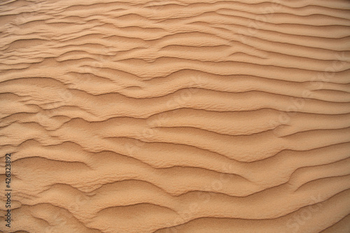 Desert. Sand dune. Sand texture. Wave pattern on the surface of the dune. Minimalism. Solid orange color palette. Grains of sand. Sandstone. No noise