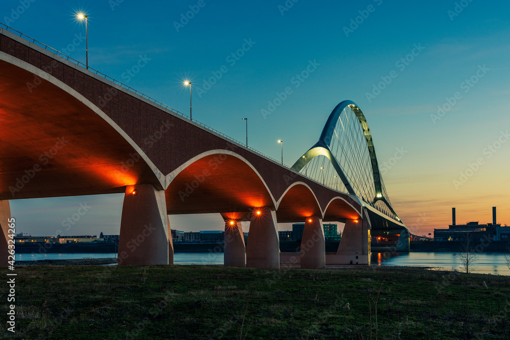 Obraz premium The De Oversteek bridge in the Dutch city of Nijmegen is illuminated in the evening.