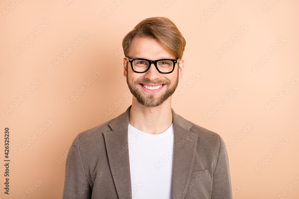 Photo of funky confident young gentleman dressed blazer glasses smiling isolated beige color background Photo of funky confident young gentleman dressed blazer glasses smiling isolated beige color background