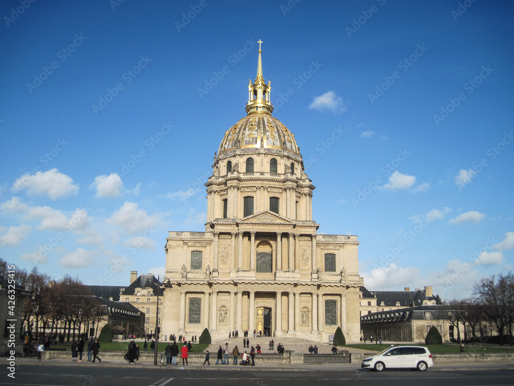 Beautiful cityscape with group of tourist sightseeing famous landmark Hotel des Invalides. Young people walking in historic place on a sunny day.