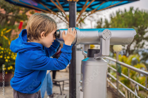 Binoscope. Stationary city binoculars. A boy looks at the city through a binoscope photo