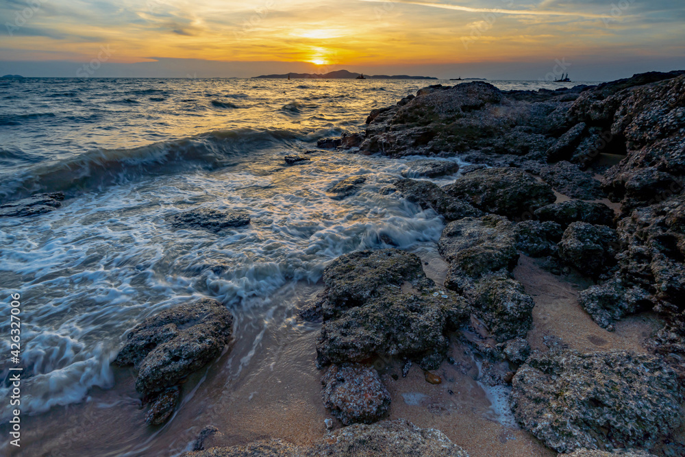 Obraz premium Sea waves crashed against rocks in the sunset at Pattaya Thailand.