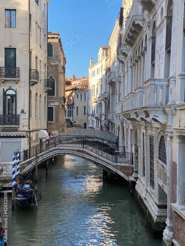 Beautiful bridge over a small canal lined, on colorful building background, Venice, Italy, during Lockdown Crisis COVID-19