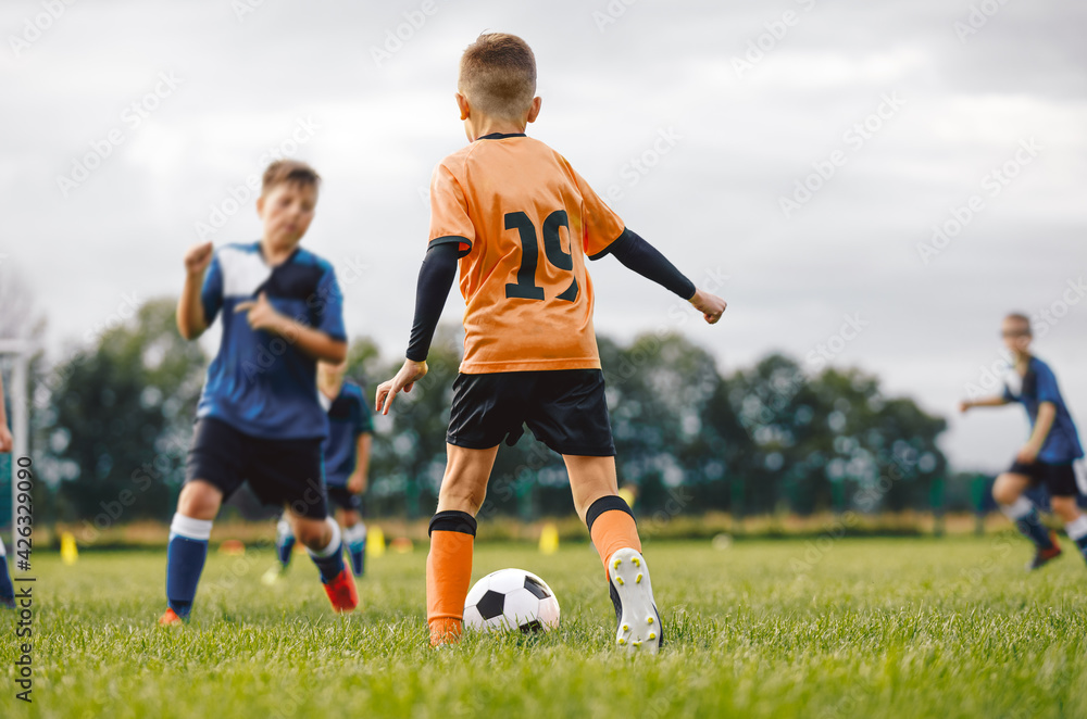 Obraz premium Boys in Two Football Teams Playing Game on Grass. School Kids Kicking Soccer Ball. Sports Education For Children. Sports Outdoor Activity for Young Boys