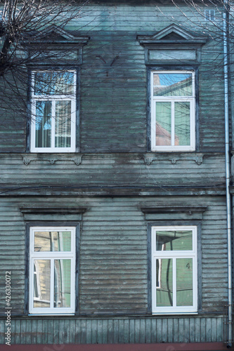 old wooden turquoise colour house facade with four windows