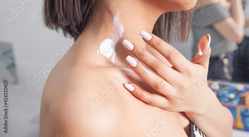 Woman taking care of her body applying cream.