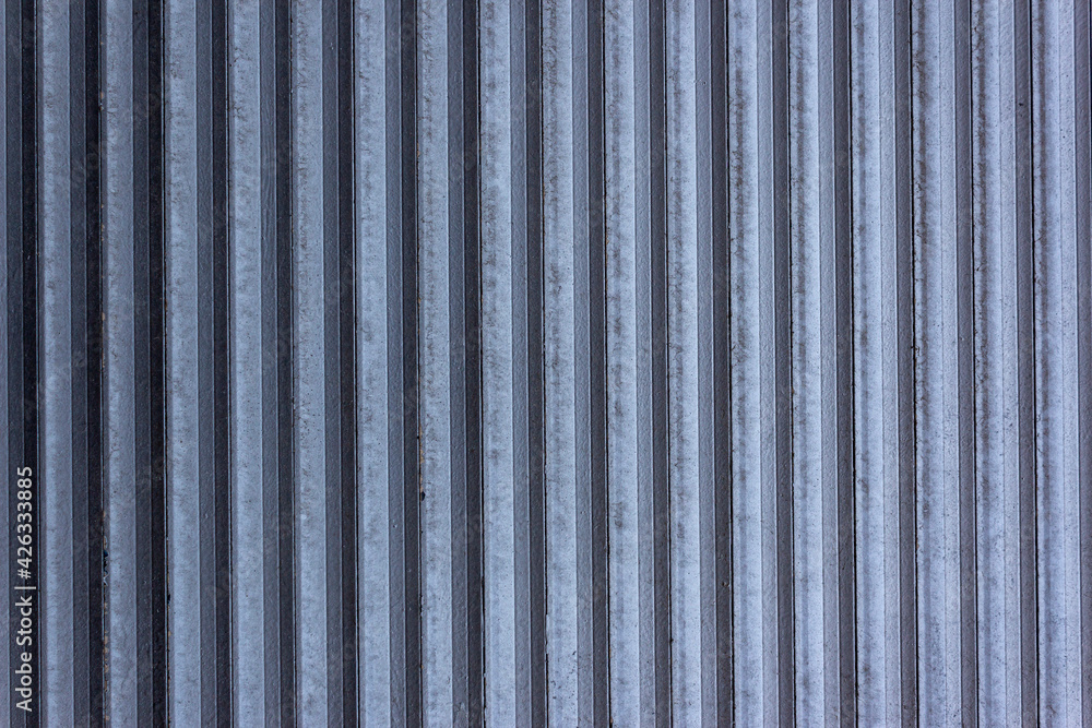 Corrugated sheet metal, badly painted with gray paint for background. Metal corrugated roofing sheet.Painting of metal surfaces for rust control Abstract background for sites and layouts. Iron fence Corrugated sheet metal, badly painted with gray paint for background. Metal corrugated roofing sheet.Painting of metal surfaces for rust control Abstract background for sites and layouts. Iron fence