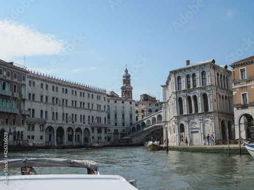 Venice old city grand canal with gondolas and boats. Romantic swimming in the morning. Comfotrable transportation to ancient historic hotel. Scenic Venetian scape on a sunny day.