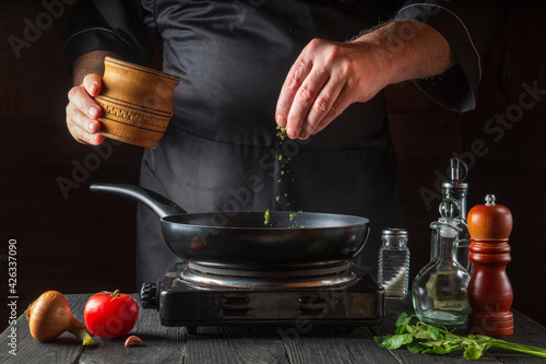 Photos Professional chef pours spices into pan