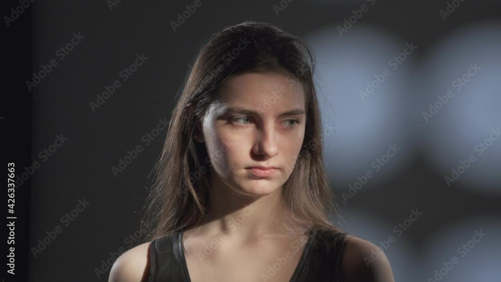Close up portrait of young girl with brown hair watching calmly into camera in studio. Close up portrait of young girl with brown hair watching calmly into camera in studio.