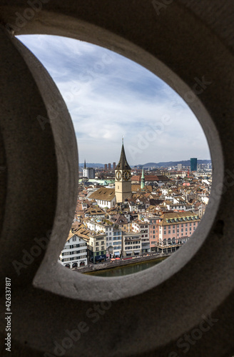 Zurich, Switzerland - March 26. 2021: Zurich downtown and St. Peter Church viewed through wall frame on the top of the church Grossmunster