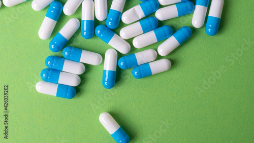 white and blue pills on green background
