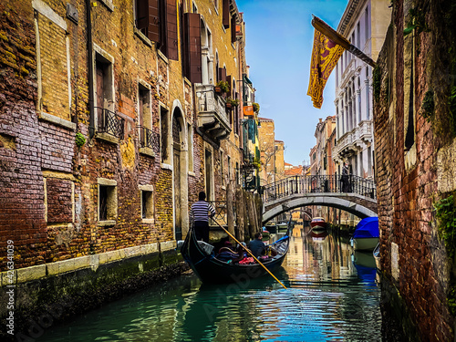 Canvas Print Gondolier seen from behind, driving a gondola with a family of tourists
