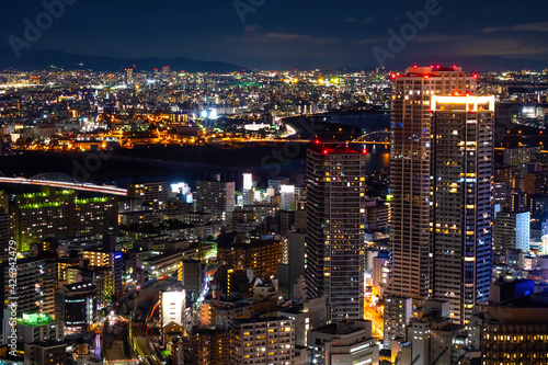 Japan. Night panorama of Osaka. Evening Osaka aerial view. Lights of the night city in Japan. Construction of overpass in Japan. River in the middle of the city. Traveling in Japan. Tour to Osaka.