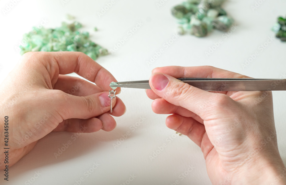 A jeweler works with gemstones. Selection and fitting of natural stones A jeweler works with gemstones. Selection and fitting of natural stones