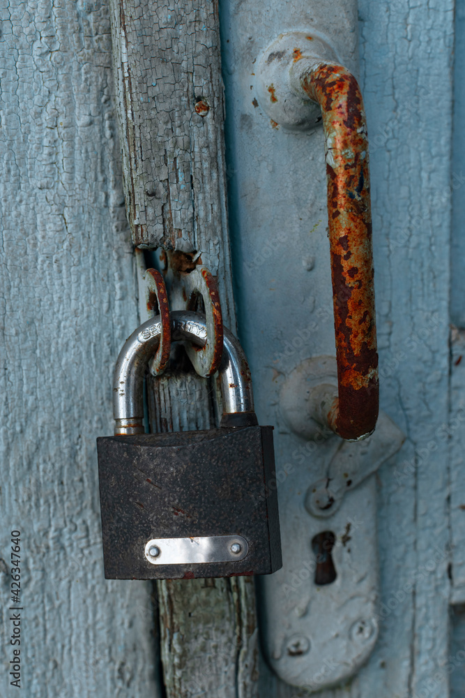 A rusty lock weighs on the door A rusty lock weighs on the door