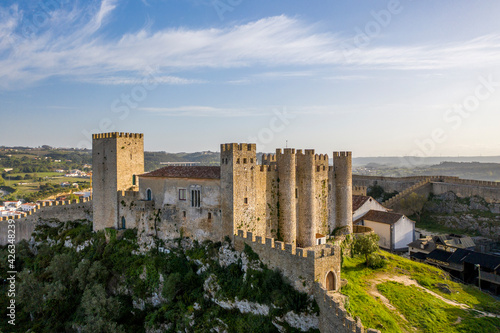 Aerial drone view over Obidos medieval Castle, in Obidos Village, Portugal. Sunset golden hour.