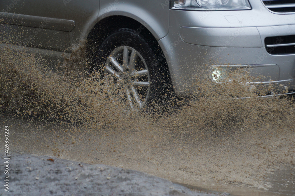 Car quickly go through a puddle throwing out splashes and water from under the wheels. Car quickly go through a puddle throwing out splashes and water from under the wheels.